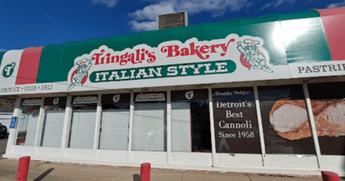 Exterior of Tringali's Bakery, featuring a colorful sign and a large display of cannoli, labeled "Detroit's Best Cannoli."