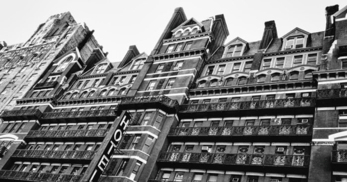 Black and white photo of a historic building with intricate architectural details and balconies.