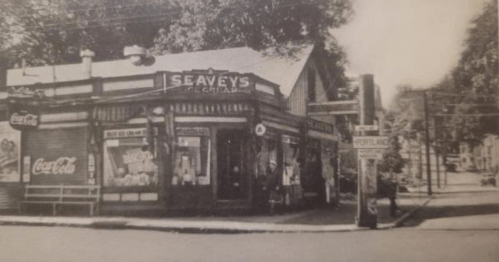 Black and white photo of Seavey's General Store, featuring vintage signage and a street view.