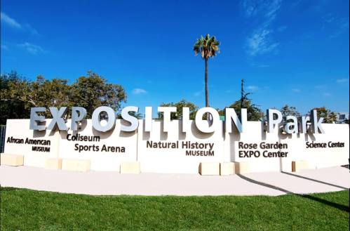 Sign at Exposition Park displaying names of attractions: African American Museum, Coliseum, Natural History Museum, and more.