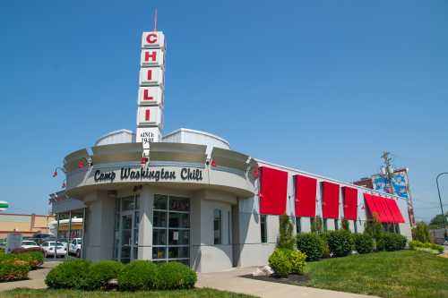 A retro-style restaurant with a prominent "Chili" sign and red awnings, set against a clear blue sky.