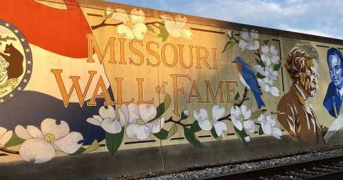 Mural featuring "Missouri Wall of Fame" with flowers, a bluebird, and portraits of notable figures.