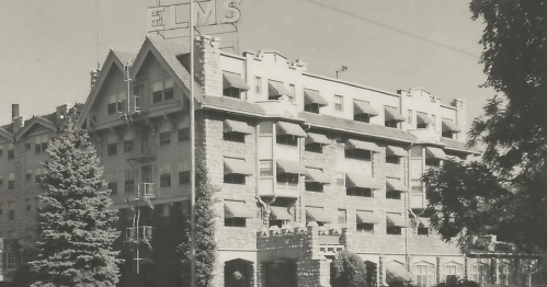 Historic black-and-white photo of the Elms hotel, featuring a stone facade and multiple windows.