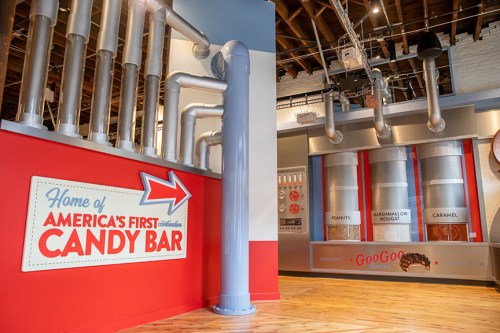 Interior of a candy bar exhibit featuring colorful signage and display cases for various candy ingredients.