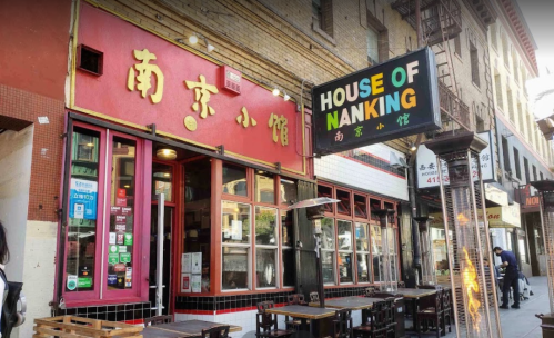 Exterior of House of Nanking restaurant, featuring red signage and outdoor seating in a bustling urban setting.