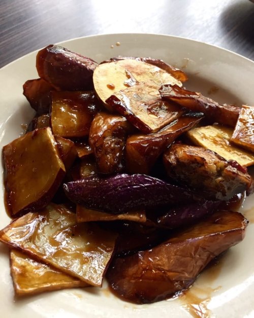 A plate of glossy, caramelized eggplant and sweet potato slices, arranged attractively.