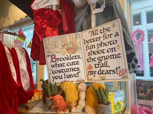 A whimsical display featuring costumes and a sign about fun photo shoots on a gnome trail, with decorative elements.