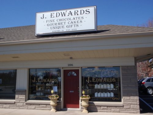 Exterior of J. Edwards store in Kokomo, IN, featuring a sign for chocolates, cakes, and unique gifts. Open for business.