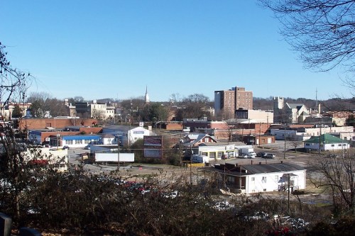 A panoramic view of a small town with buildings, churches, and a clear blue sky in the background.