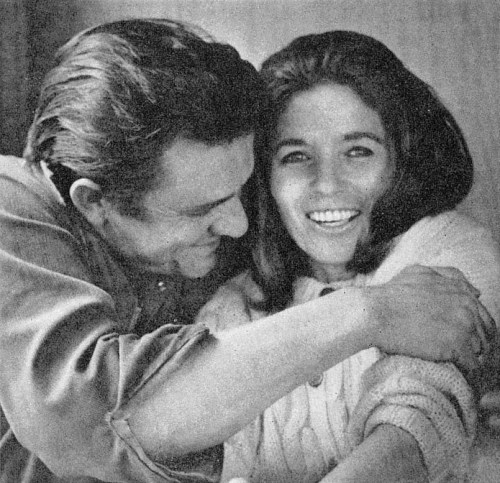 A man and woman share a joyful moment, smiling and embracing each other warmly.