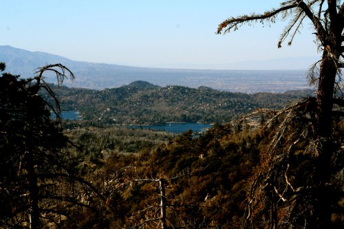 A scenic view of a mountainous landscape with lakes and trees, under a clear blue sky.