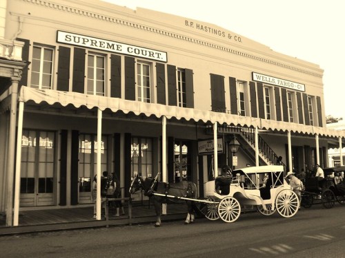 Historic building with a horse-drawn carriage in front, featuring signs for the Supreme Court and Wells Fargo.