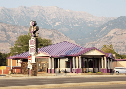 A purple-roofed restaurant with mountains in the background, featuring a sign that reads "Bubble Tonic."