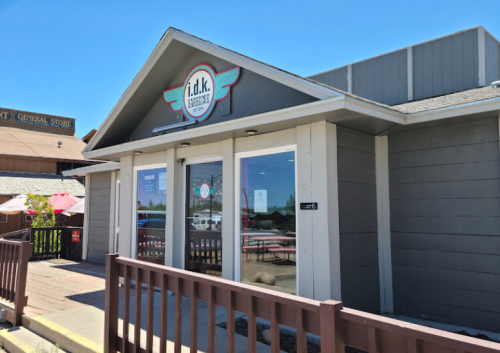 Exterior of a restaurant named "i.d.k." with a modern design and a clear blue sky in the background.