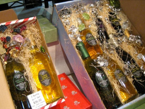Two gift boxes containing bottles of wine, decorated with ribbons and straw, priced at $26.00 for a two-bottle set.