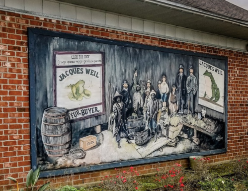Mural depicting a historical scene with people, barrels, and signage for Jacques Weil, a fur buyer.