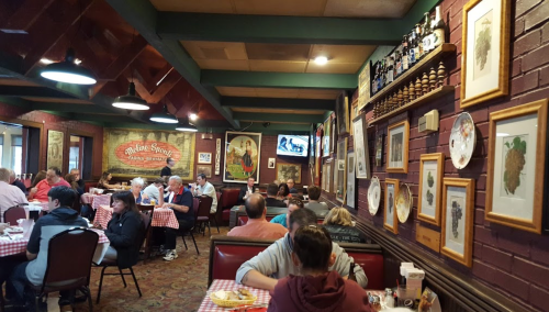 A cozy restaurant interior with checkered tablecloths, diners enjoying meals, and vintage decor on the walls.