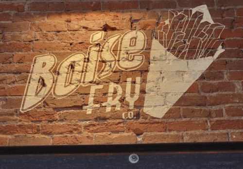 A brick wall featuring the logo for Boise Fry Co., with a graphic of a French fry container.