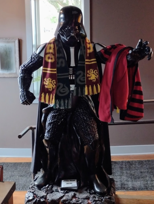 A statue of Darth Vader wearing a scarf and holding a robe, blending Star Wars and a school spirit theme.