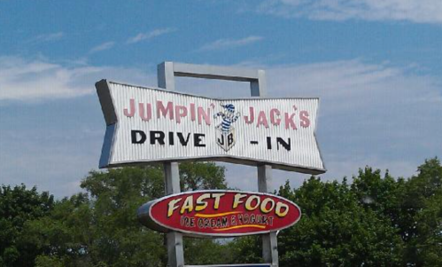 Sign for Jumpin' Jack's Drive-In featuring "Fast Food" and "Ice Cream Products" against a blue sky.