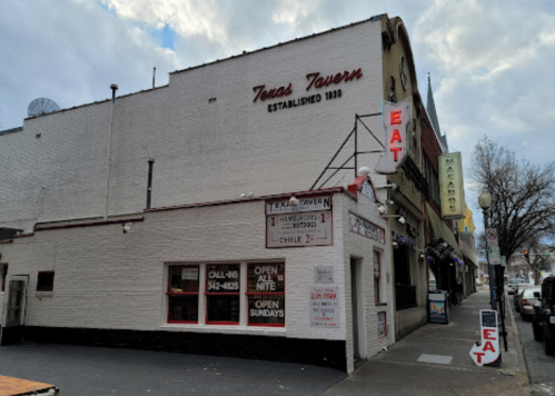 Exterior of Texas Tavern, established 1933, featuring signage and a classic brick facade. Open all night.