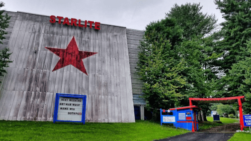 A weathered building with a red star and "STARLITE" sign, featuring a marquee for upcoming events and a colorful entrance.