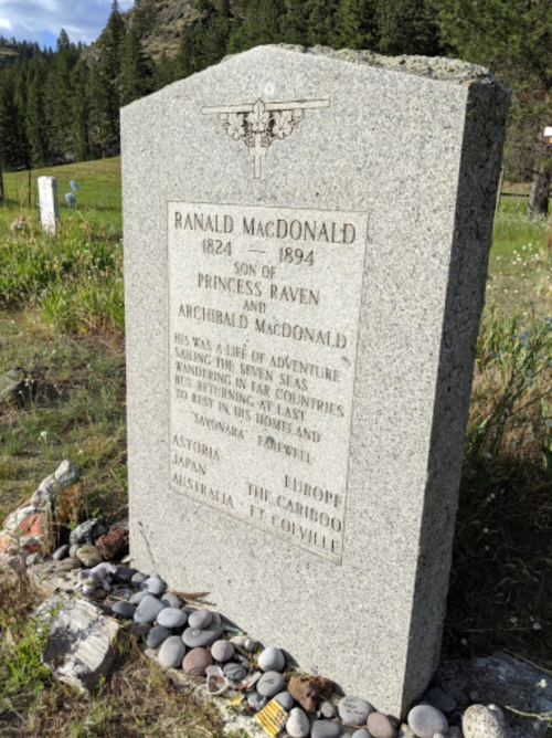 Gravestone of Ranald MacDonald, 1824-1894, with inscriptions about his adventurous life and travels. Surrounded by stones.