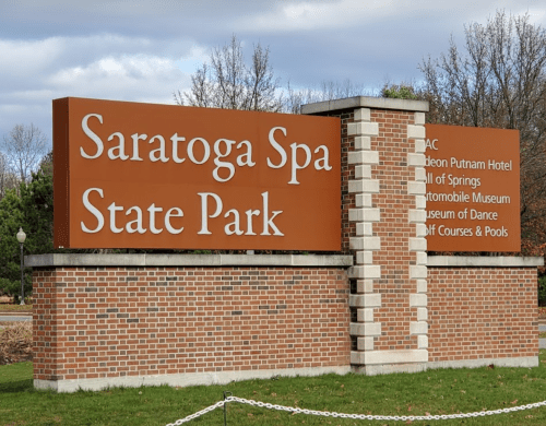 Sign for Saratoga Spa State Park, listing attractions like the Gideon Putnam Hotel and Automobile Museum.
