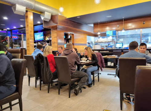 A busy restaurant interior with diners at tables, enjoying meals in a warm, inviting atmosphere.