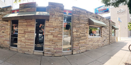 Exterior of a restaurant with stone walls and awnings, featuring a sign that reads "American Restaurant."