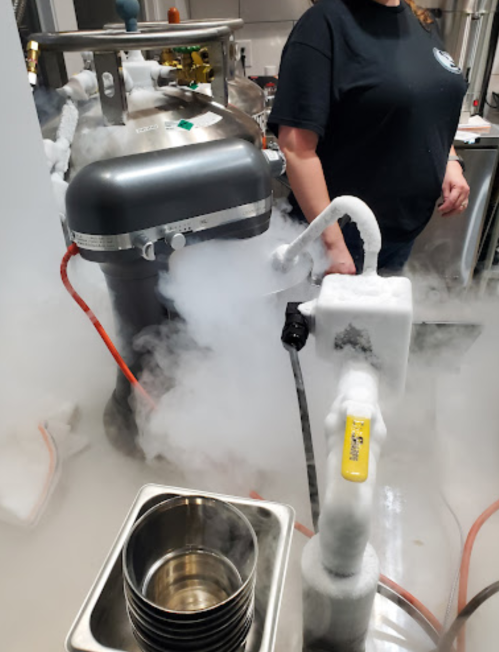 A kitchen scene with a mixer and a fog of liquid nitrogen, creating a dramatic effect around the equipment.