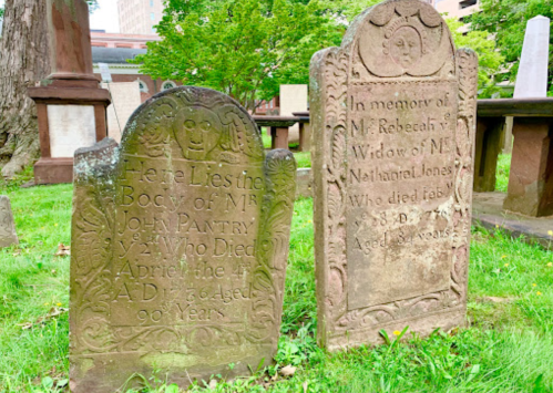 Two old gravestones in a grassy cemetery, one for John Pantry and the other for Rebeccah, detailing their ages and dates.