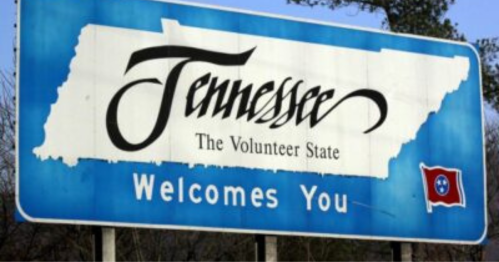 Welcome sign for Tennessee, featuring the state outline, "The Volunteer State," and the Tennessee flag.