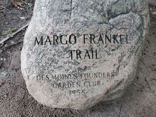 A large rock with engraved text reading "Margo Frankel Trail, Des Moines Founders Garden Club, 1958."