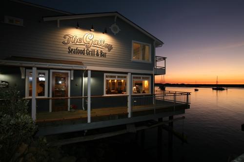 A seafood grill and bar at sunset, with boats in the water and a warm glow from the restaurant's windows.
