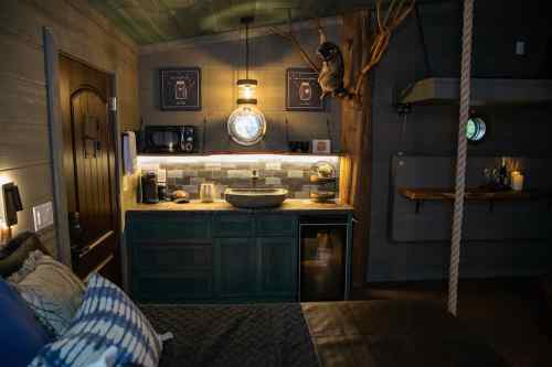 Cozy interior of a small cabin featuring a kitchenette, wooden accents, and a rustic decor style.