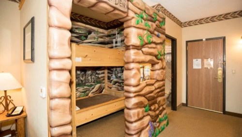 A cozy children's bunk bed area designed like a log cabin, with playful decor and a warm atmosphere.