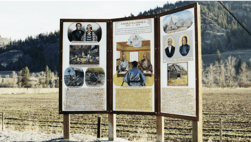Historical information display featuring images and text about local history, set against a rural landscape.