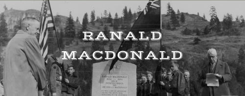 A historical photo featuring a monument for Ranald Macdonald, with people gathered around in a natural setting.