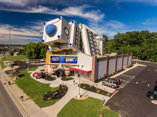 A whimsical building resembling a giant camera, with playful architectural features and a colorful sign.