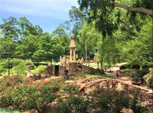 A scenic park featuring unique sculptures, lush greenery, and walking paths under a clear blue sky.