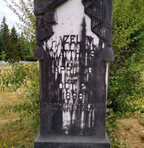 A weathered gravestone for Hazel Matthias, born April 18, 1898, with inscriptions partially obscured by wear.