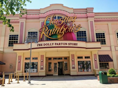 Exterior of the "Chasing Rainbows: The Dolly Parton Story" museum, featuring colorful signage and a sunny day.