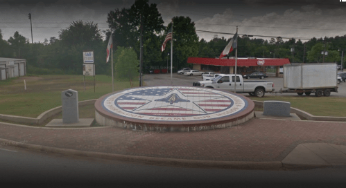 A large star-shaped monument with an American flag design, surrounded by flags and a grassy area.