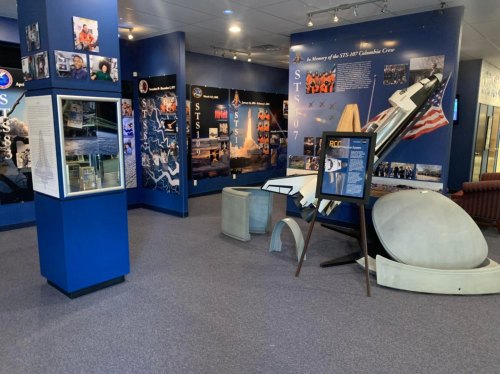 Exhibit space featuring displays about the STS-107 Columbia crew, with photos and artifacts related to space exploration.