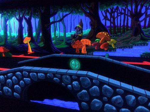 A vibrant, glowing scene of a forest with colorful mushrooms and a stone bridge under a dark, illuminated sky.