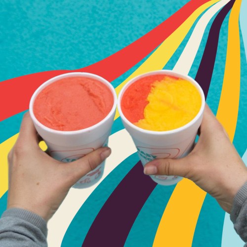 Two hands hold large cups of colorful slushies, one red and one yellow, against a vibrant, wavy background.