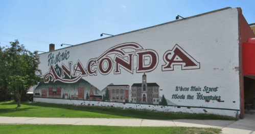 Mural on a brick wall reading "Historic Anaconda" with a scenic background and the tagline "Where Main Street Meets the Mountains."