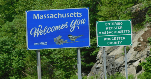 Two roadside signs: one welcoming to Massachusetts, the other indicating entry into Webster, Worcester County.