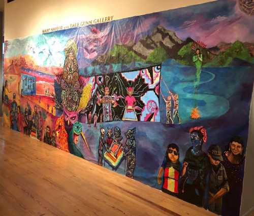 Colorful mural featuring diverse figures and scenes, blending cultural elements and artistic styles on a gallery wall.